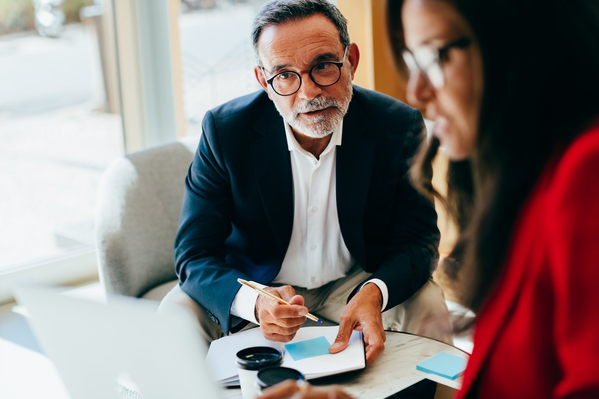 Focused senior manager conversing with a colleague in an office
